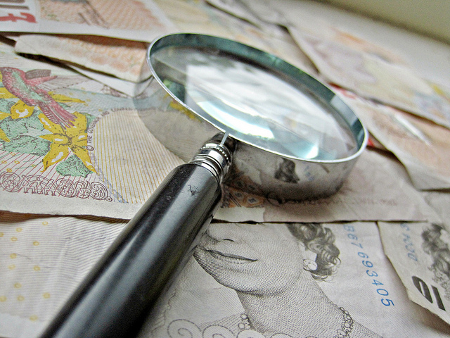 British paper money and magnigying glass