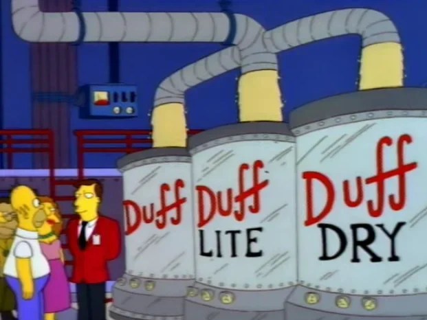 Homer Simpson standing in front of 3 vats of beer: Duff, Duff Lite, and Duff Dry. A pipe is pouring the same beer into all 3 vats.